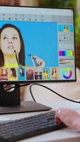 Vertical Expert artist woman edits digital photos on her computer in a creative office. Her home workspace equipped with editing software, enhancing artistic work in the industry. Camera B. video