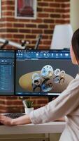 Vertical Professional industrial designer working with CAD software on dual monitors, creating 3D prototypes for a tech driven environment. 3D modeling software for innovative design. Camera B. video