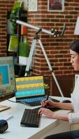 Vertical Creative woman manages photo editing and design projects on her computer in a tech driven workspace, using digital tools to enhance productivity in the graphic design industry. Camera A. video