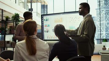 Team of company analysts reviews feedback on sales and orders to work on improvements, developing marketing and PR strategies in meeting room. Startup enterprise affiliates. Camera B. video