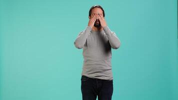 Man covering eyes, ears and mouth, imitating three wise monkeys. Arab person doing dont see, dont hear and dont speak hand gesturing concept, studio background, camera A video