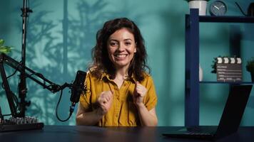 innehåll skapare använder inspelning redskap till skjuta inledande segmentet för vlog kanal, stänga upp. Lycklig internet stjärna välkomnar hängiven fläkt gemenskap, införande i dag ämne, kamera b video