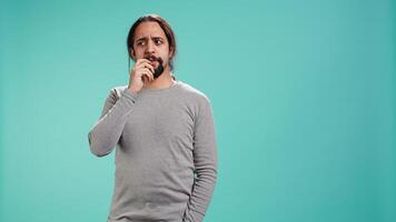 Portrait of man feeling perplexed by confusing information, isolated over studio background. Person scratching head, looking around with puzzled facial expression, camera B video