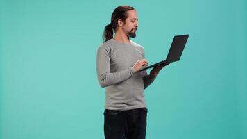 Man using laptop to do business related tasks for company, isolated over studio background. Office clerk doing budgeting, forecasting, and financial analysis on notebook, camera A video