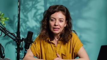 Smiling influencer doing story time type of for fans, filming in personal home studio. Jolly internet star telling subscribers about what happened to her, keeping audience engaged, camera A video