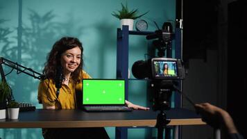 Woman filming herself watching internet videos on mockup laptop requested by viewers. Online influencer reacting to online clips sent by subscribers using green screen notebook, camera B