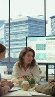 Vertical General director sharing insight about a new expansion strategy with her employees, presenting data reports to analyze business activity status. Coworkers in a briefing meeting. Camera B. video