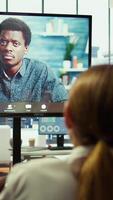 Vertical General manager checking on his staff via remote videocall connection in a boardroom, meeting to discuss latest project updates to achieve enterprise objectives. Professional work team. Camera B. video