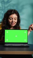 Vertical Internet show host being sponsored by partnering brand to do green screen laptop unboxing content. Tech specialist does influencer marketing, doing mockup notebook product placement, camera B video