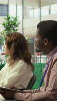 Vertical Diverse group of professionals meeting to discuss a new development strategy, utilizing infographics and monthly analysis numbers to reach target and accomplish organizational goals. Camera B. video