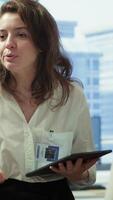 Vertical Employees attending an online remote videocall meeting with general manager, presenting project updates for efficiency. Work team ensuring strategic goals achievement in a boardroom. Camera A. video