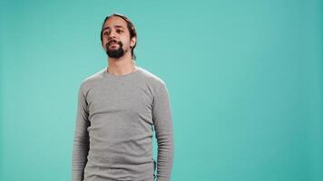 Assertive man doing stop hand gesture sign, studio backdrop. Annoyed person doing firm halt sign gesturing, wishing to end concept, isolated over blue studio background, camera B video