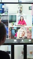 Vertical General manager starts a meeting on online videoconference call in the boardroom, discussing about updates with his staff. Business associates reviewing financial planning for growth. Camera A. video