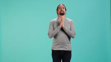 Pious man praying to his god, asking for forgiveness. Spiritual person doing worship hand gesturing, confessing, begging for pardon, isolated over studio background, camera A video