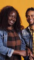 Vertical African american romantic couple smiling and posing next to each other, being in love and showing affection in front of the camera. Happy husband and wife embracing with passion. Camera B. video