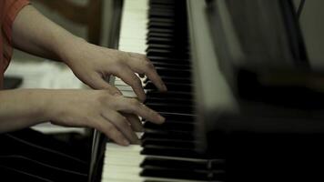 Girl's hands on the keyboard of the piano. The girl plays piano,close up piano. Hands on the white keys of the Piano Playing a Melody. Women's Hands on the keyboard, Playing the Notes Melody. photo