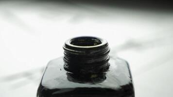 Female hand dunks brush in a jar of ink for drawing close up. Chinese Old-fashioned Paint Brushes with Selective Focus. Detail of a chinese brush while drawing a line in light back photo