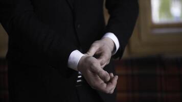 Man buttoning on a black jacket. Wedding details - elegant groom dressed wedding tuxedo costume is waiting for the bride. businessman buttoning jacket, getting dressed. Groom buttons jacket photo