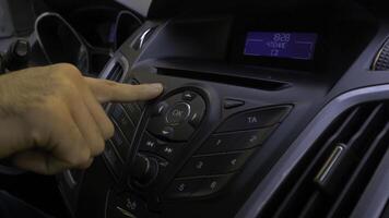 Man's hand puts the disk into the car player. Button control for compact disk player in a car. Hand puts the disk into the radio car photo