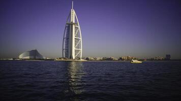 A landscape view of Dubai beach and sea in summer. Stock. Famous building and fishing boats background. UAE photo