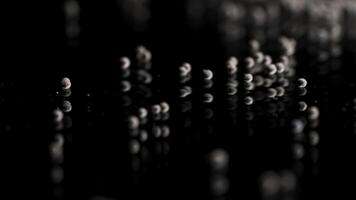 Close up of tiny gravel pile left on reflective black surface. Stock footage. Small stones at the laboratory during quality control of contruction materials process. photo