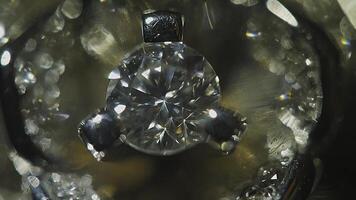 Diamond solitaire ring closeup in dark environment. Big blue diamond, closeup view. layered triangular macro diamond shapes with a small diamond over them. Round gemstone on Black Background with photo