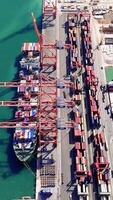 Cargo ship navigating toward a loading dock at an industrial harbor, preparing for container operations, highlights the effectiveness of maritime logistics and global trade video