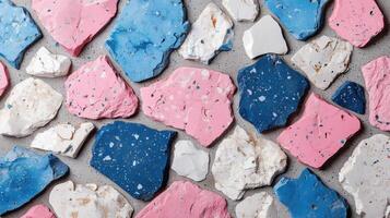 Colorful terrazzo pieces in pink, blue, and white arranged on a surface, ideal for design backgrounds. photo