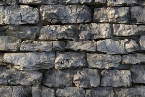 A wall made of gray stones with a rough texture photo