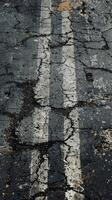 Cracked road with yellow line. Distressed urban background. photo
