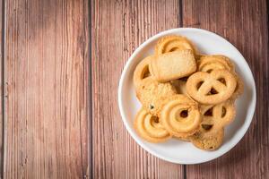 Five whole pretzel, round and rectangular shortbread biscuits with sugar on wood background. photo