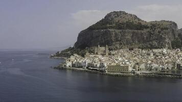 Scenic aerial view of picturesque island with huge mountain surrounded by small houses with the endless sea on the background. Action. Summer seascape of the island and a village. photo