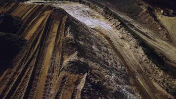 Top view of sand quarry, mining of natural resources or ore, heavy industry concept. Stock footage. Aerial of the quarry with many wheel traces. photo