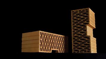 Two new perforated red bricks placed on black stand, building and construction materials concept. Stock footage. Bricks moving on black background. photo