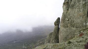 Nature landscape, view from the top of the hill on yellow and green valley in thick fog. Shot. Aerial for steep slope of a mountain, green and dry fields in foggy clouds. photo
