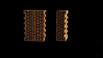 Close up of two red bricks moving against black background, construction and materials concept. Stock footage. New bricks isolated on black background. photo