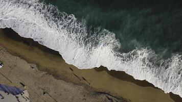 Sand beach. Stock. Top view of a beautiful sandy beach with the blue waves rolling into the shore. Sea background photo