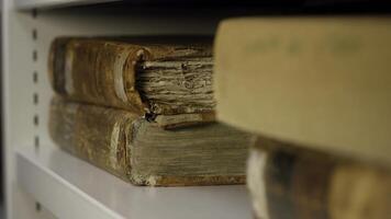 Expert takes an old book from the shelf. Stock footage. An ancient relic taken by gloved hands photo