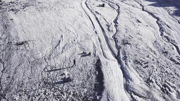 Top view of mountaineer resting in snowy mountains. Clip. Active traveler rests high in snowy mountains. Spectacular views for mountain climbers relaxing on sunny day in mountains photo