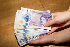 Stack of Twenty-Pound Banknotes Held in Hand photo