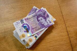Stack of Twenty-Pound Banknotes on Wooden Table photo