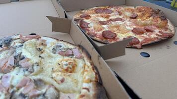 Two Delicious Pizzas in Cardboard Boxes photo