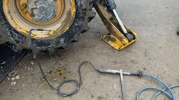 Tractor Tire Maintenance with Hydraulic Jack photo