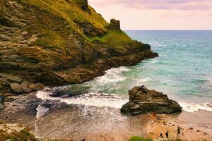 Scenic Coastal Beach with People Enjoying Nature in Tintagel, Cornwall, UK photo