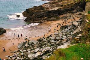 Scenic Rocky Beach with People Exploring in Tintagel, Cornwall, UK photo