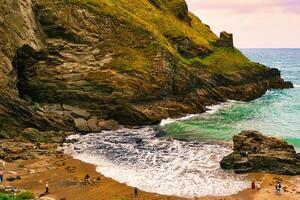 Scenic Beach with Rocky Cliffs and Gentle Waves in Tintagel, Cornwall, UK photo