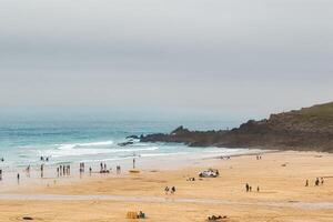 Calm Beach Scene with People and Overcast Sky in St Ives, Cornwall, UK photo