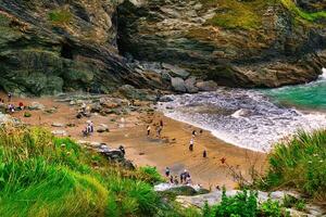 Scenic Beach with People and Rocky Cliffs in Tintagel, Cornwall, UK photo