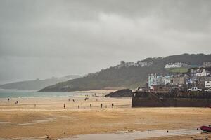 Coastal Beach Scene Under Cloudy Sky in St Ives, Cornwall, UK photo