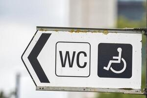 Directional Restroom Sign with Accessibility Symbol photo